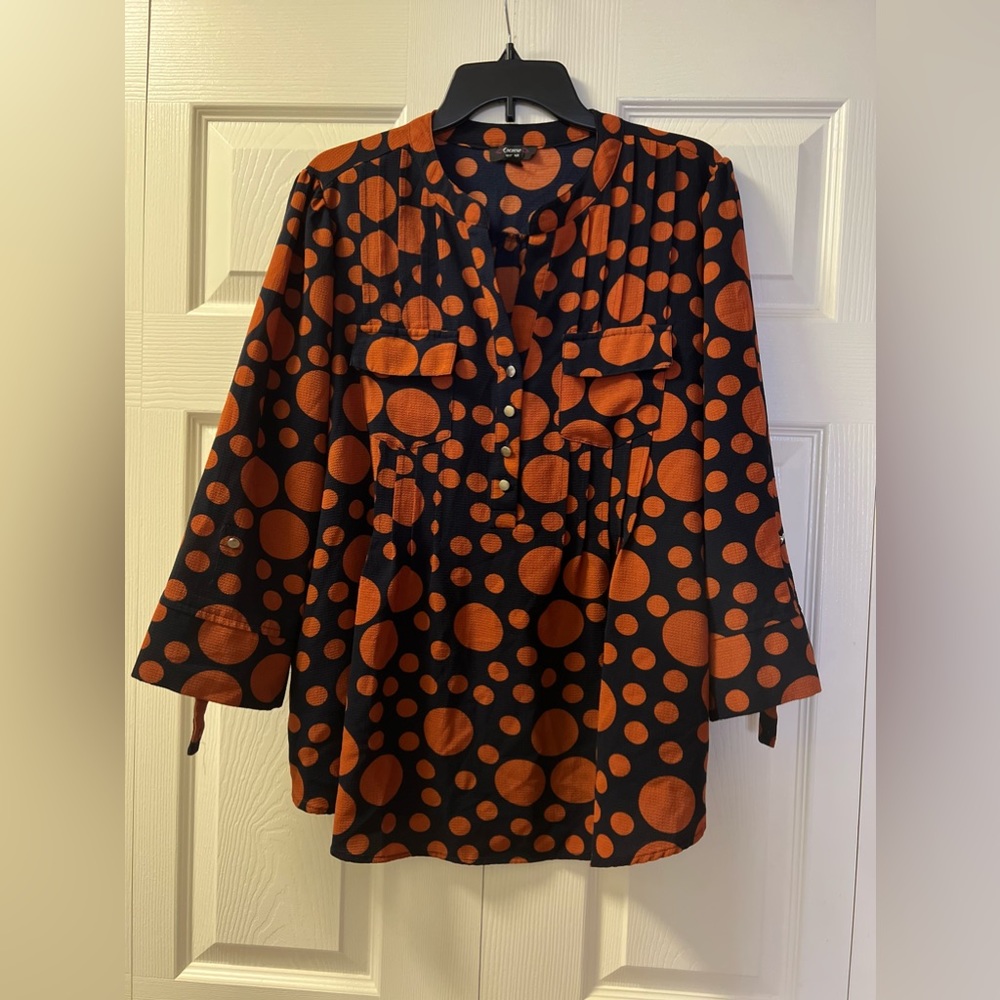 An orange and blue blouse is a colorful and striking choice.